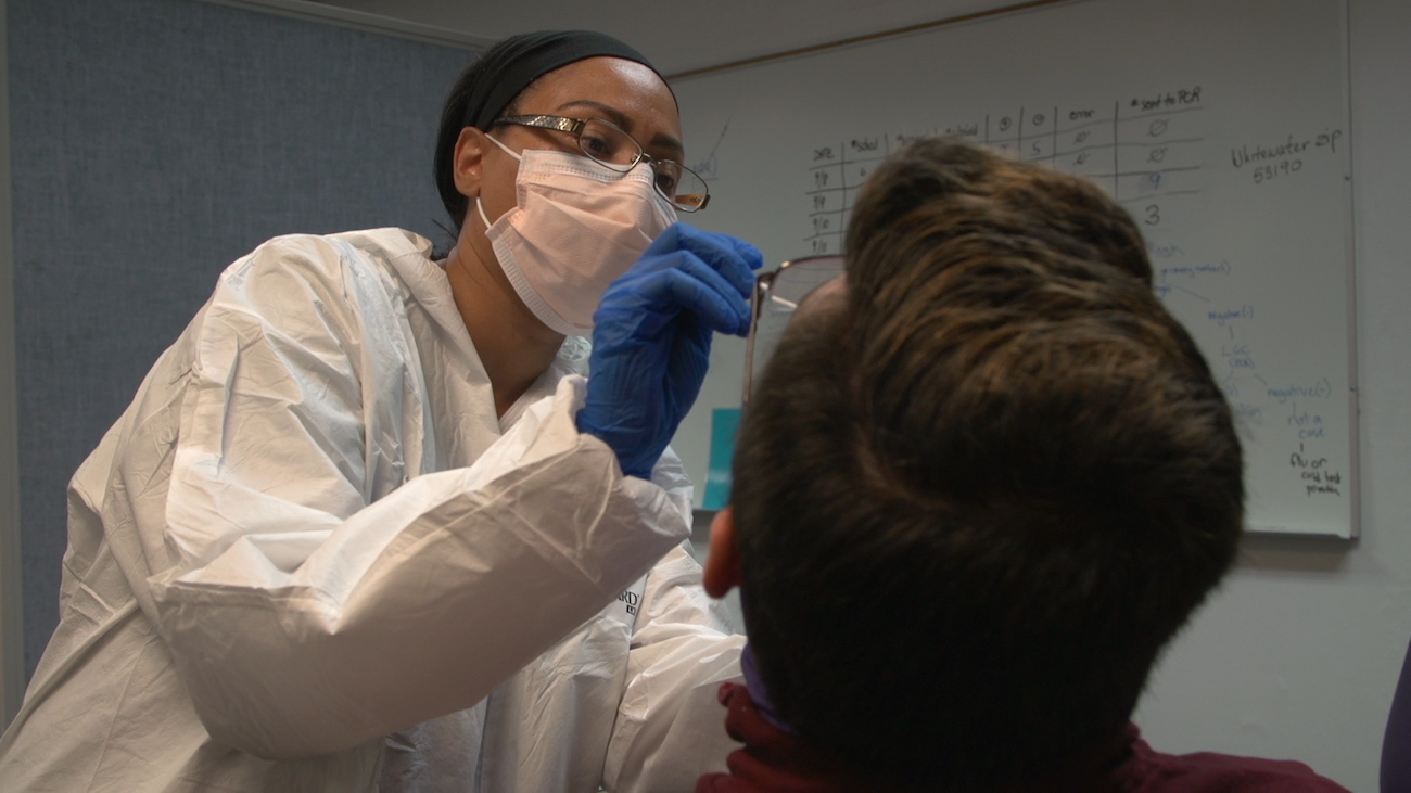 Nurse testing a student for antigen.