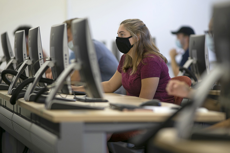 Student at desk wearing a facial covering.