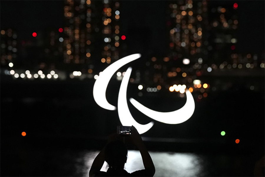 Paralympic symbol with city lights in the background.