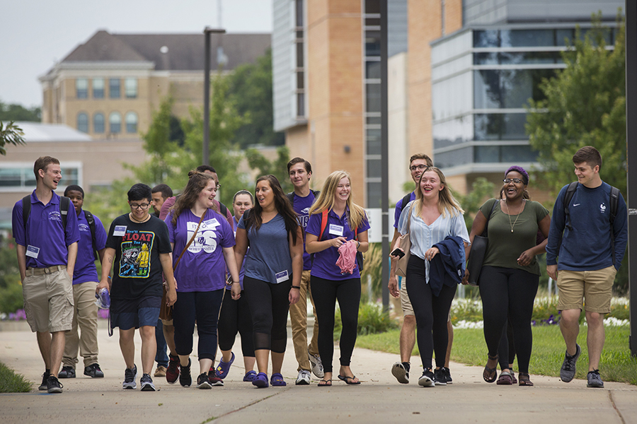 Students walk down a sidewalk on campus.