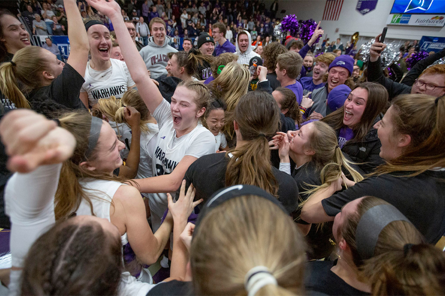 Fans and players celebrate on the court.