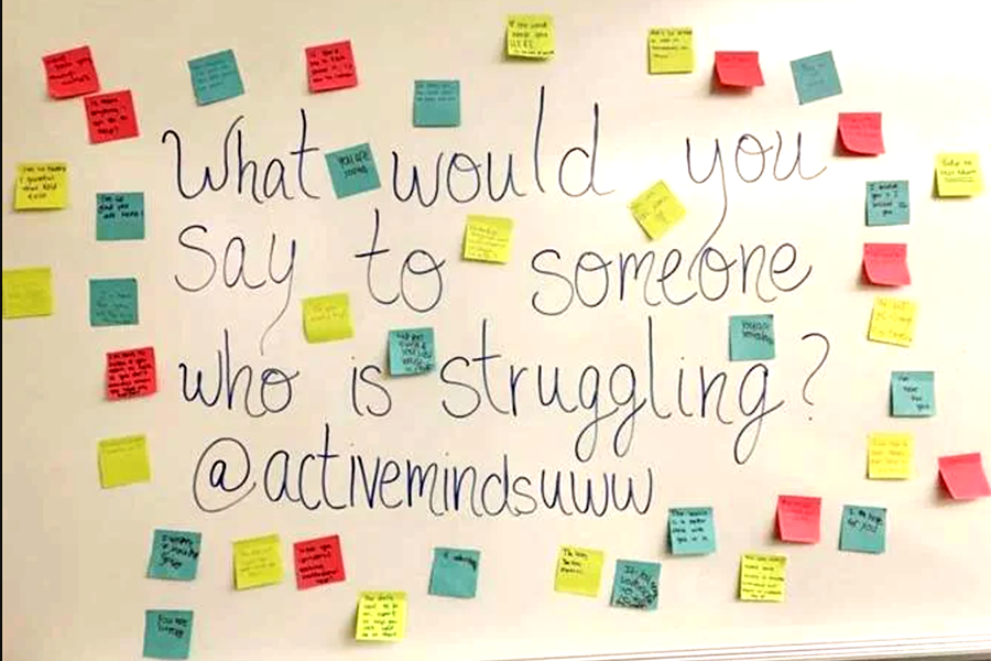 A white board full of positive messages on sticky notes.