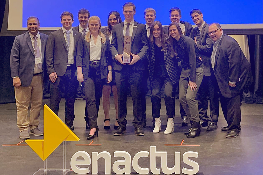 Students in the Enactus chapter pose with their trophy.