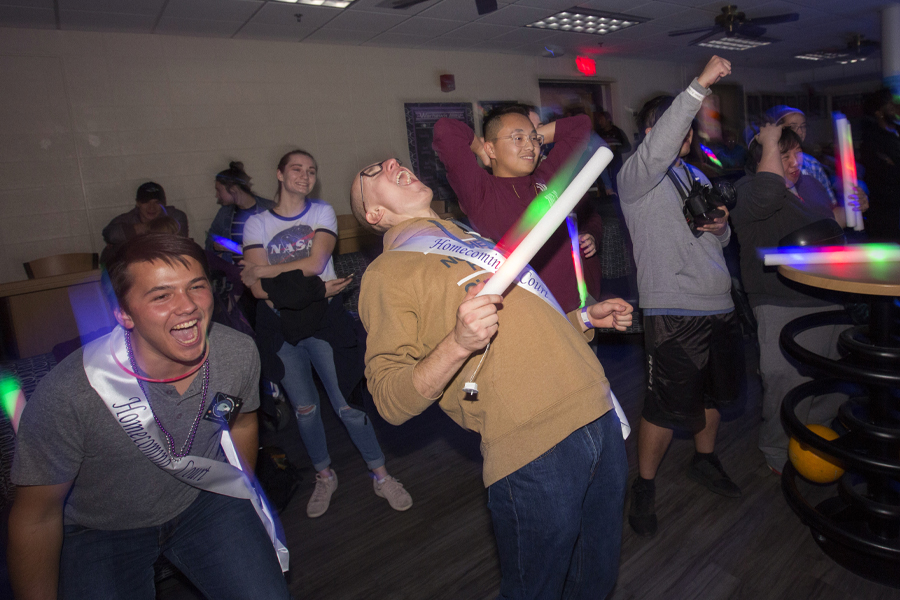 Students cheer in the University Center with glow sticks.