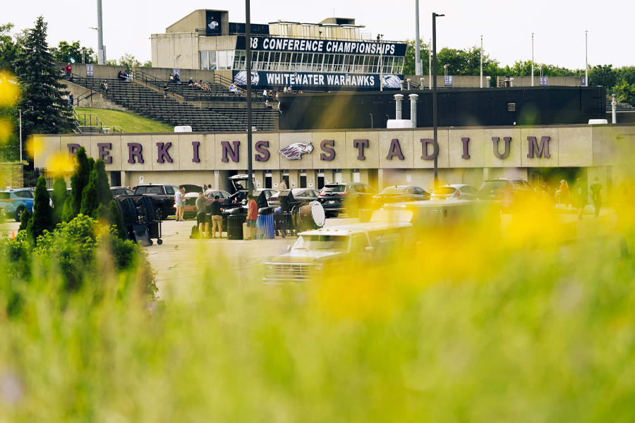 Perkins Stadium sign on the building with grass in the foreground.