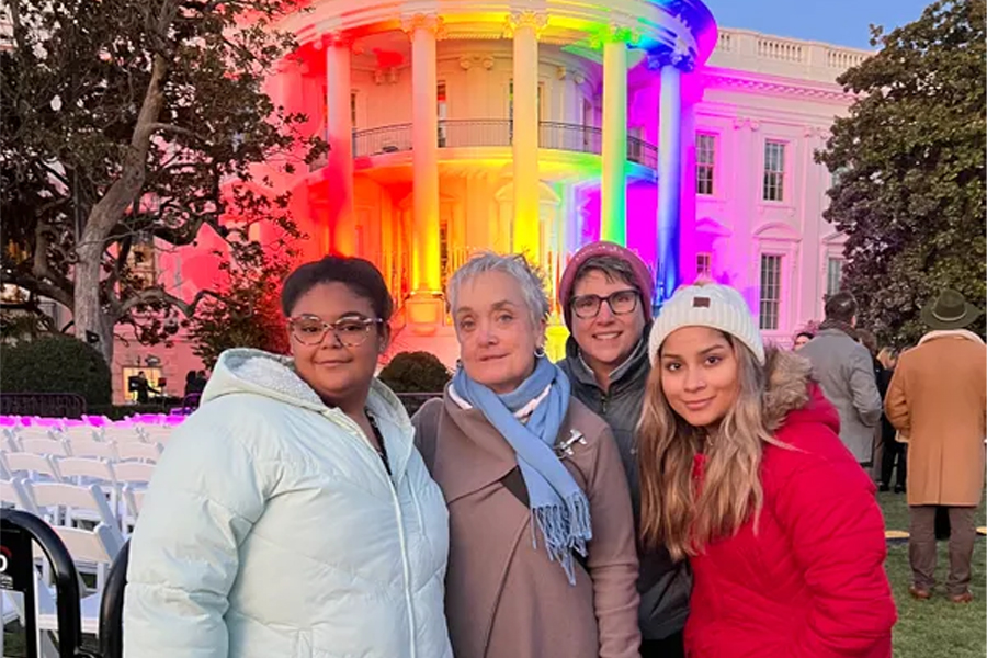 A family of four stands outside the White House.
