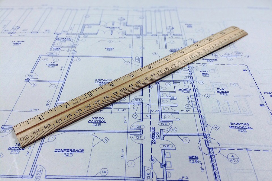 A building plan with a ruler on top.