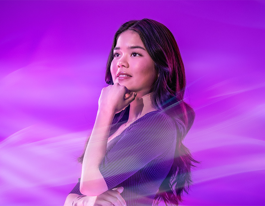A person wearing a purple shirt looks at something off camera.