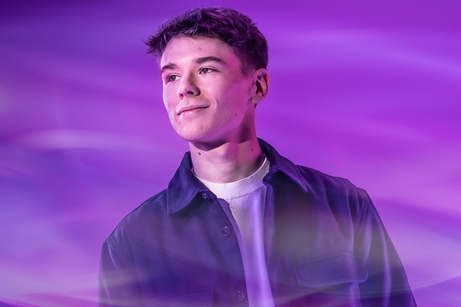A person on a purple background looks into the distance. 