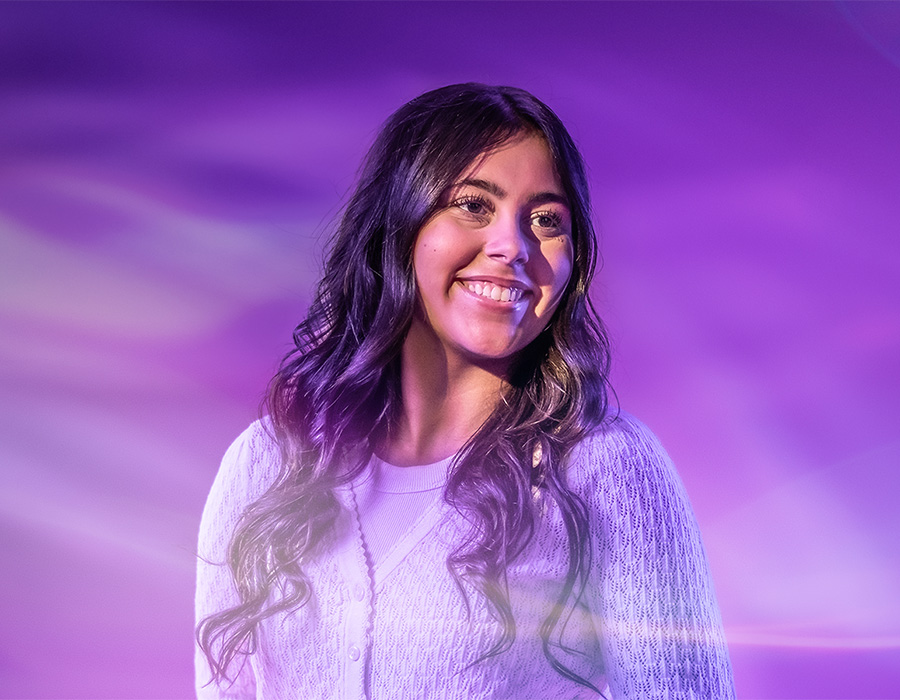 Student with laptop poses for UW-Whitewater College of Business and Economics online
