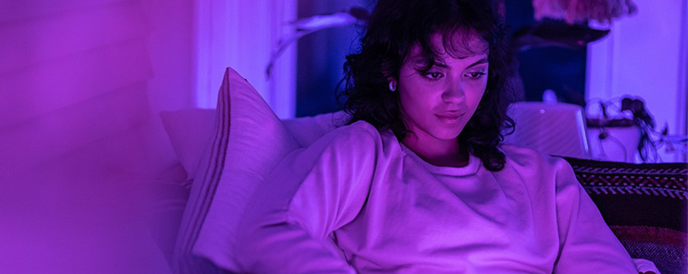 Young woman reclines while taking online college class