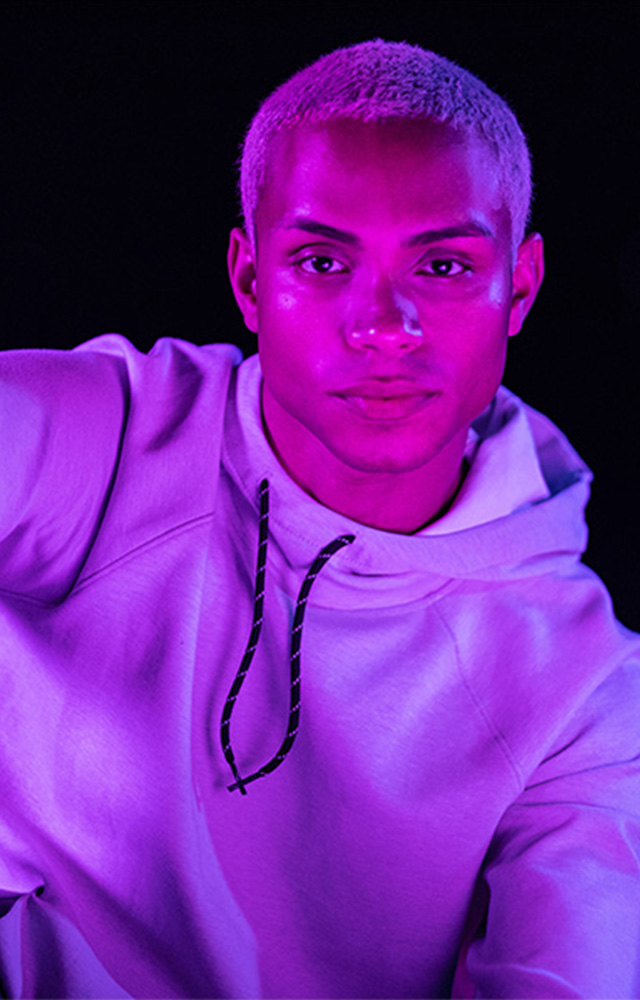 Young man reading tablet in purple light for online college class