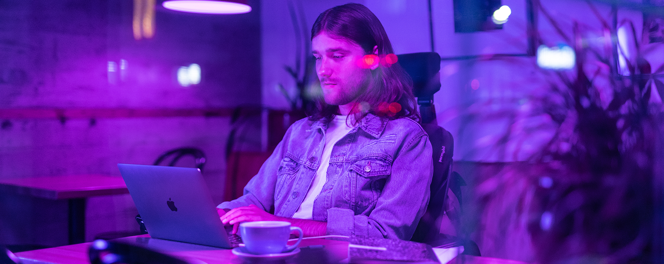 Young man in wheelchair working on laptop for online college class