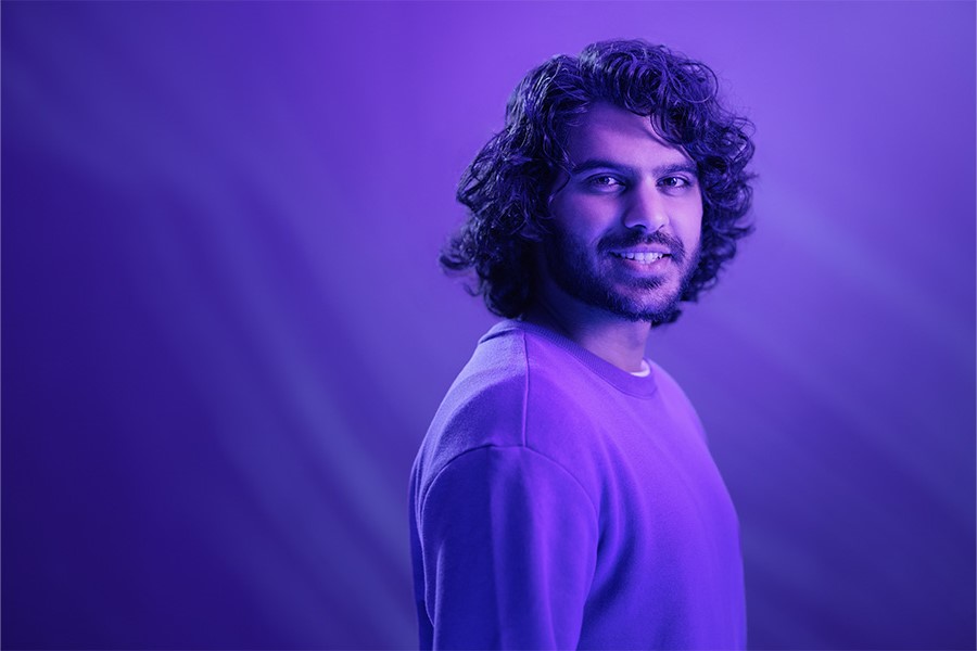 A person stands with a smile on their face.