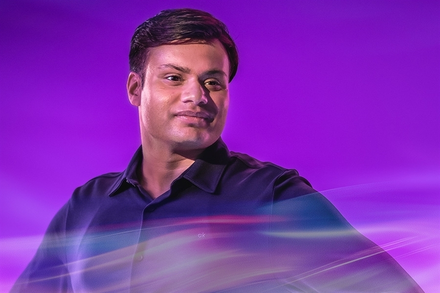 A person in a purple light looks off into the distance.