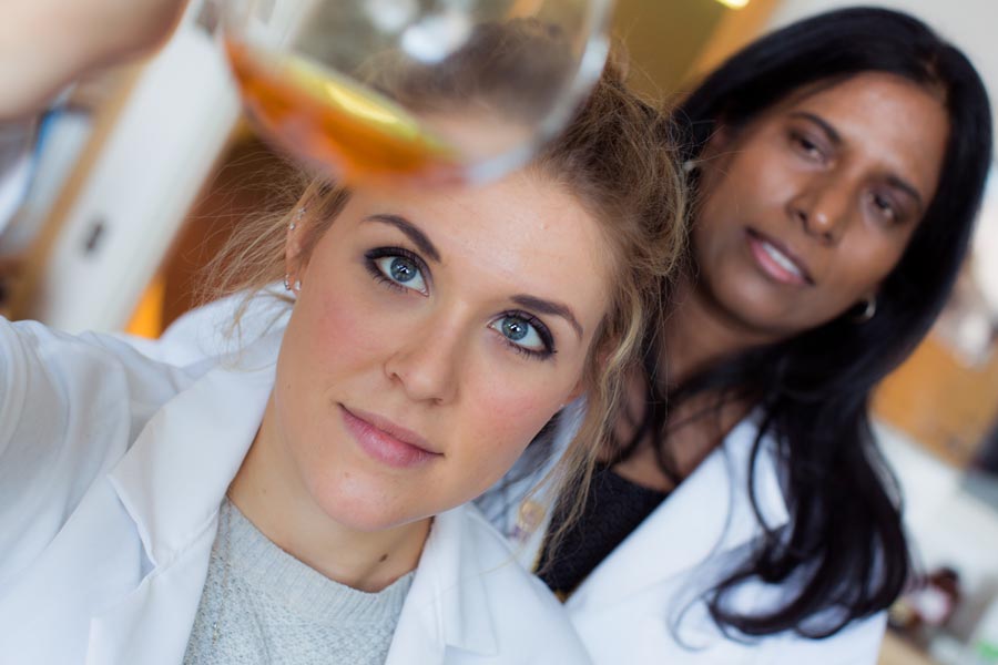 Image: A student and professor in a chemistry lab holding a test tube.