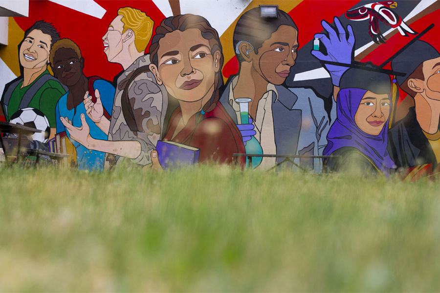 A large, colorful mural on shows people of different sizes, shapes and colors.