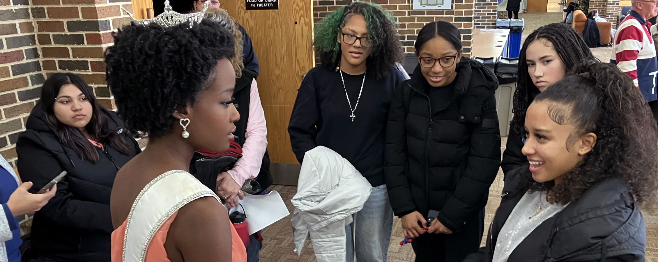 A group of people talk to Miss Wisconsin.