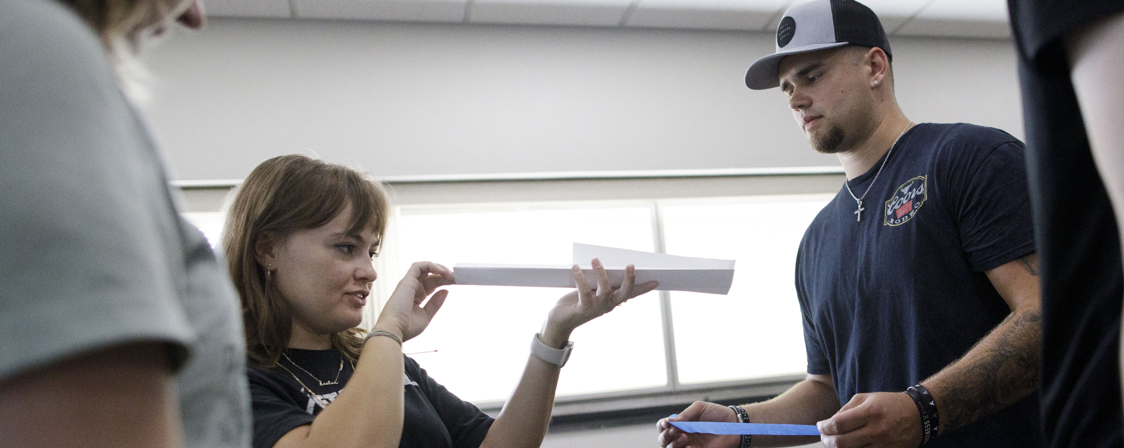 Students work on engineering simulations with a piece of paper.