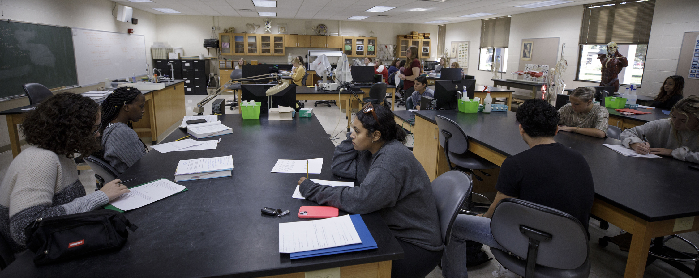 Students sit at lab tables in a classroom.