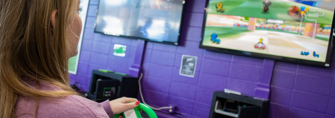 Student playing video game in Warhawk Alley