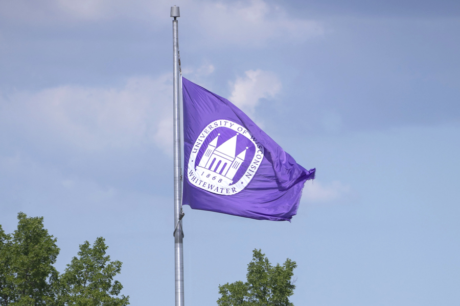 Purple UW-Whitewater flag with sky in the background.