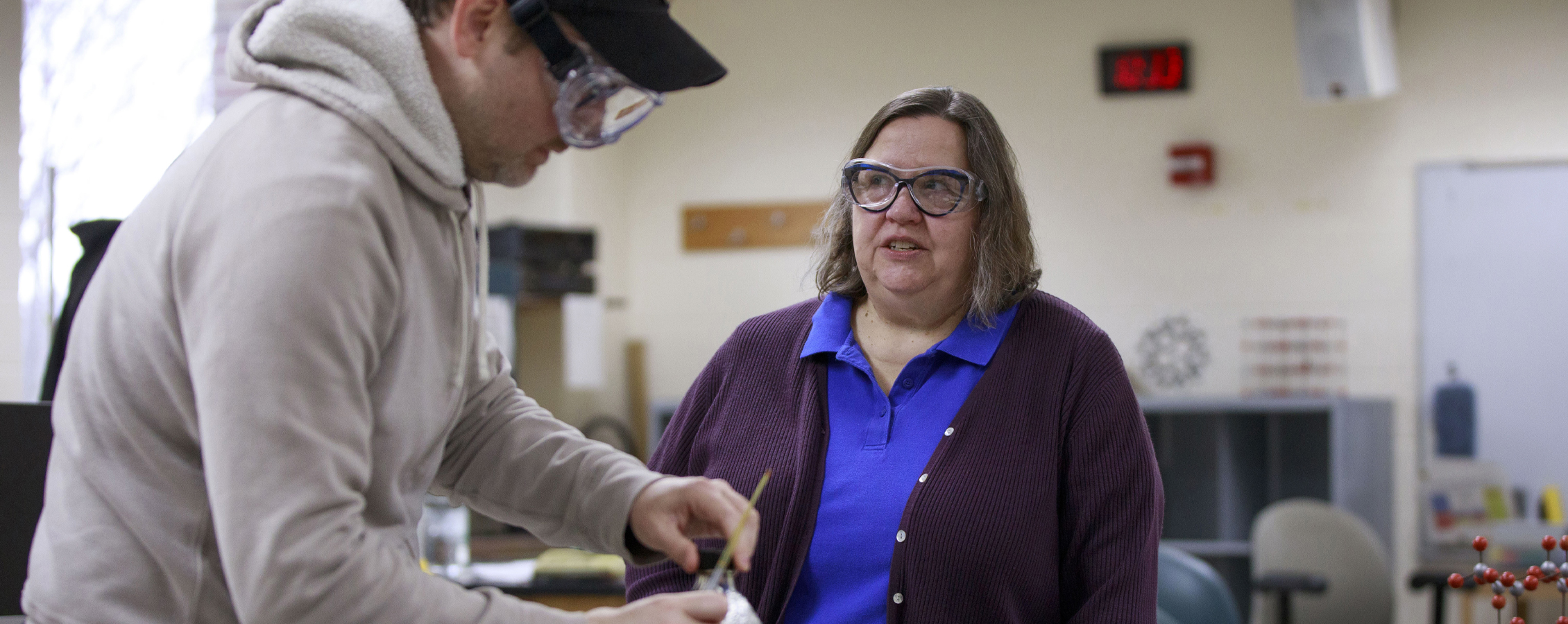 Kim Kostka works with a student in a science lab.