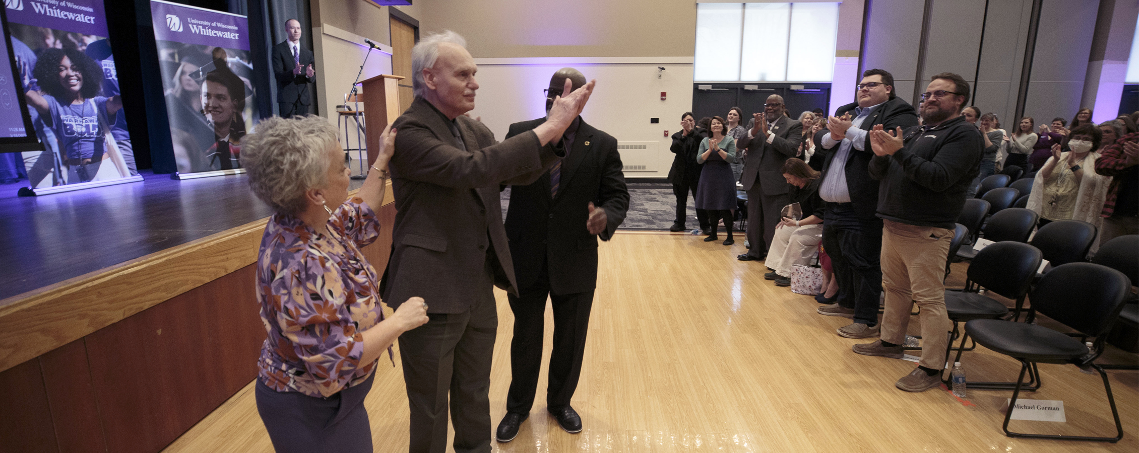 Group of people clapping at the State of the University Address.