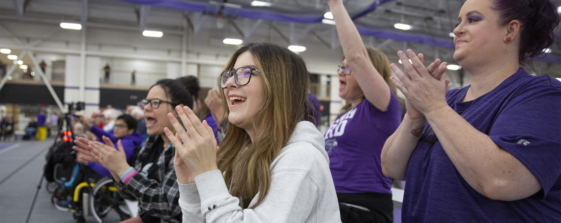 A group of people clap and cheer.